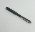 A black metal thread cutting tool with a threaded cutting head and a square socket at the end, photographed on a light gray textured fabric background.