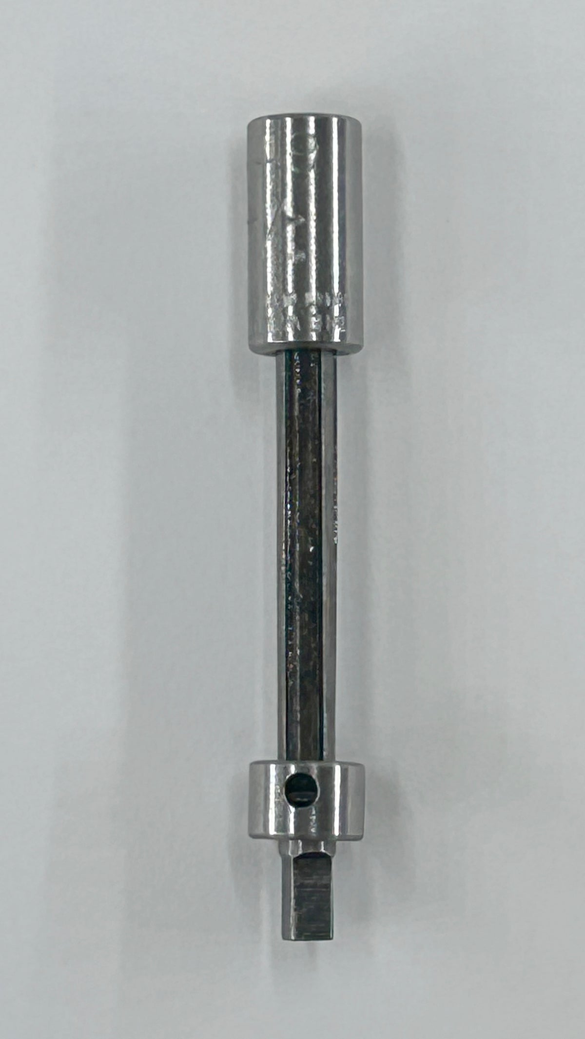 A metallic socket extension bar tool with a polished silver finish, shown vertically against a plain light gray background.